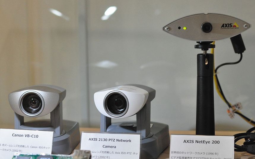 アクシスコミュニケーションズは、1996年に世界初のIPカメラを開発した。日本法人のオフィスには、現在も稼働する初号機「AXIS NetEye 200」（右端）が置かれている。PTZカメラ（中央）を初めて開発・販売したのも同社だ