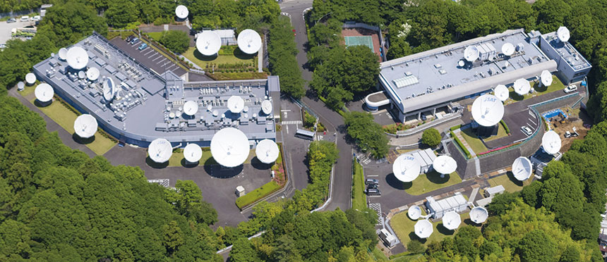 Universal NTNの実証試験で用いられている可搬型地球局（左）、試験を実施している横浜衛星管制センター。管制センターの地球局設備と可搬型地球局の間で、GEO衛星を介して通信が行われている