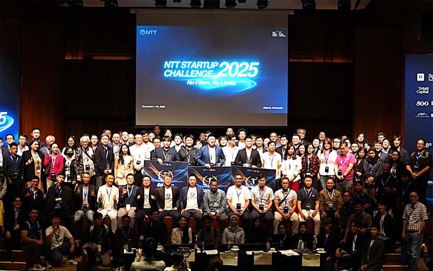 Large group of people posing on a stage in front of a screen reading 'NTT Startup Challenge 2025'