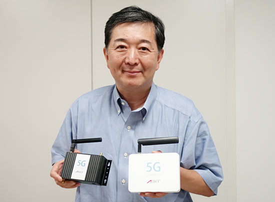 エイビット代表取締役社長 CEOの檜山竹生氏。手にしているのは、ローカル5G用基地局装置（左）と端末（右）