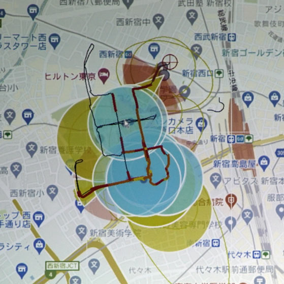 RFスキャナーの測定結果に基づいて地図上に表示した東京・西新宿地区の5G基地局の設置状況（青い円が5G基地局、黄色の円がLTE基地局）。装置を載せた車両を図中に線で示されたルートに沿って走らせて計測を行った
